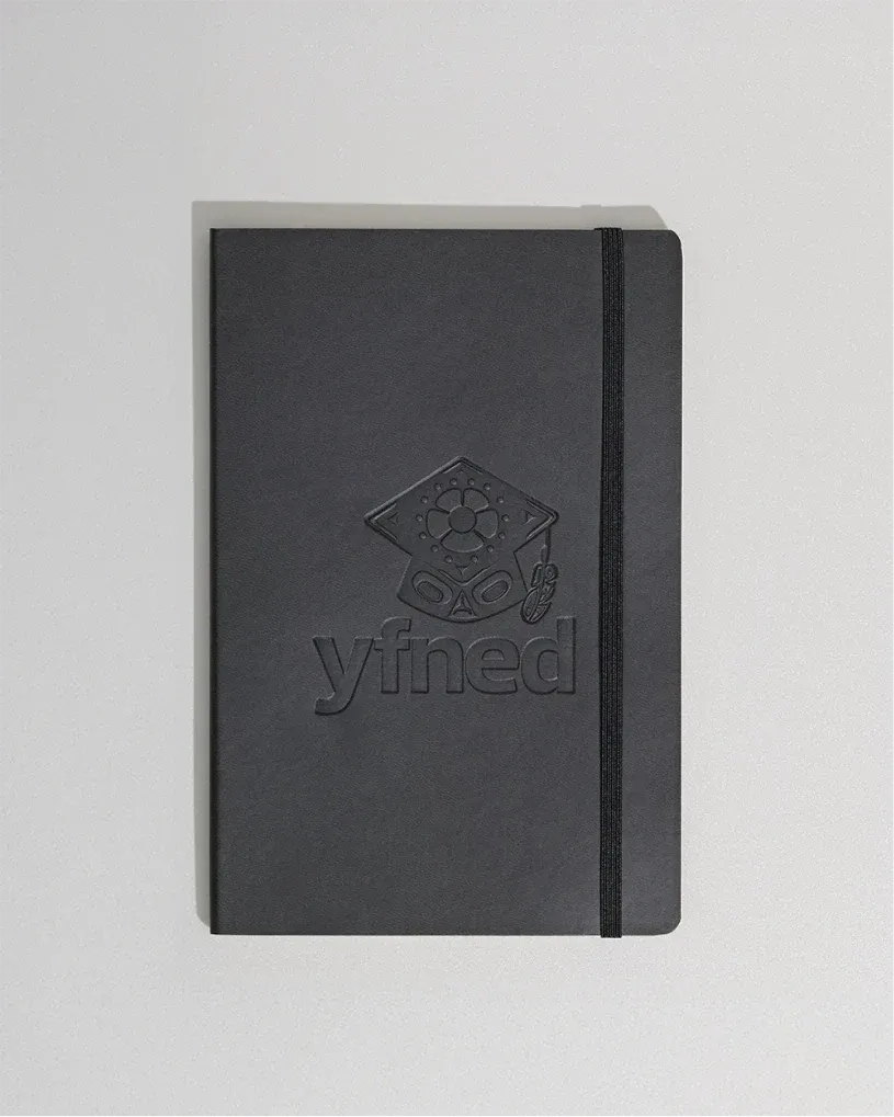 Matte black YFNED notebook with the logo debossed on the cover.