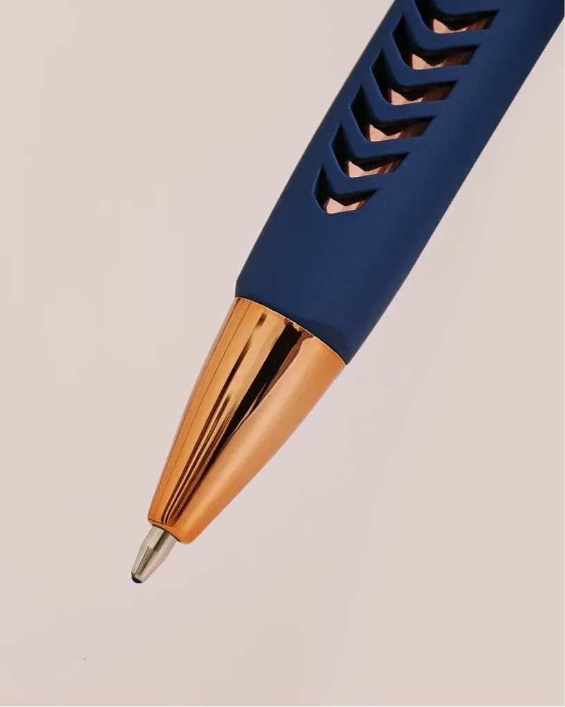 Close-up of a blue YFNED pen tip with a gold metal point and textured grip.